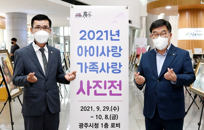  신동헌(오른쪽) 시장과 임일혁시의장이 전시장을 찿아 관계자들을 격려하고 사랑의 하트 포즈를 하고 있다.. (사진=광주시 제공)