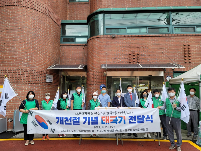 의정부시 신곡2동 시민단체들이 나라 사랑하는 마음을 담아 오는 3일 개천절을 기념해 동오마을 상가마다 태극기를 전달했다. (사진=의정부시 신곡2동 제공)