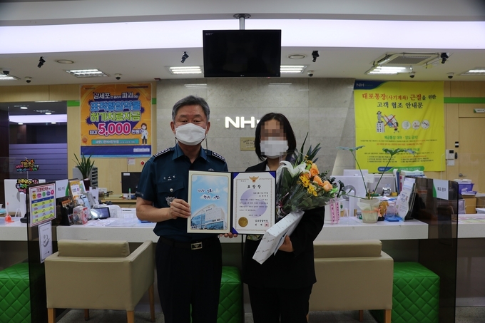 보이스피싱 수거책을 검거하는데 공을 세원 은행직원이 김포경찰서 전재희 서장으로부터 표창창을 받고 기념사진을 찍고 있다. (사진=김포경찰서)