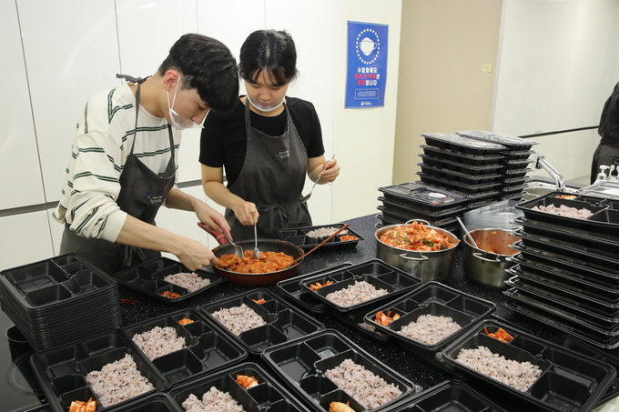학생들이 정성껏 준비한 반찬을 도시락에 담고 있다. (사진=가천대학교 제공)