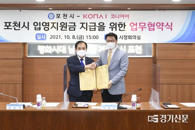 박윤국 포천시장과 코나아이㈜ 변동훈 부사장이 서명한 협약서를 들어보이고 있다. (사진=포천시 제공)