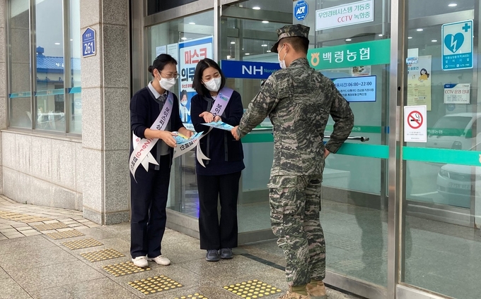 농협 직원들이 '금융사기 대포통장' 피해 예방 홍보전단지를 백령지점을 방문한 장병에게 나눠주고 있다. ( 사진 = 인천농협 제공 )