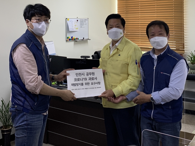 13일 인천시청에서 '인천시 공무원 코로나19 과로사 재발방지 및 처우개선을 위한 대책위원회' 홍준표 집행위원장(왼쪽)과 추인호 공동대표(오른쪽)가 정형섭 시 건강체육국장에게 코로나19 방역업무 근여건 개선 요구사항을 전달하고 있다. ( 사진 = 대책위 제공 )