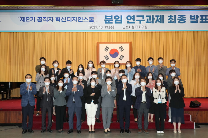 군포시 현신디자인스쿨 분임 연구과제 최종 발표회, 참여 공무원들과 심사위원단 기념사진.