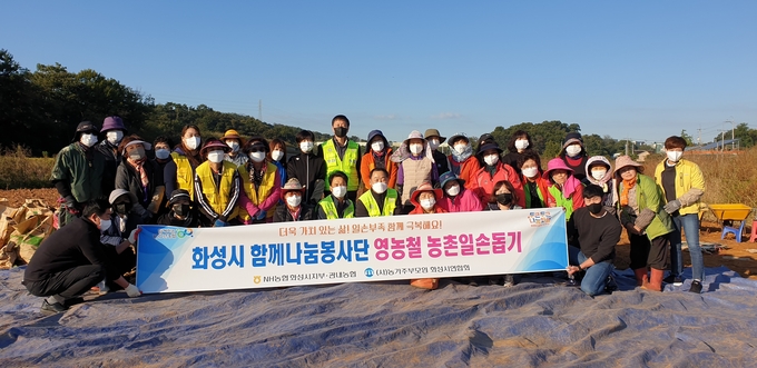 NH농협 화성시지부 임직원 및 농가주부모임 화성시연합회 등 자원봉사자 50여 명이 영농철 농촌일손돕기 구마 수확을 마치고 기념촬영을 하고 있다. (사진=NH농협 화성시지부 제공)