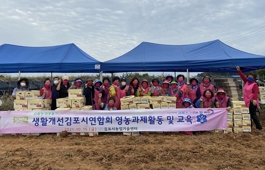 어려운 이읏에게 전달키 위해 수확한 고구마를 생활개선 김포시 연합회 회원들이 기념사진을 찍고 있다.(사진=생활개선연합회제공) 