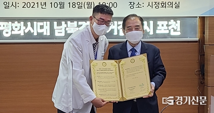 박윤국 포천시장과 백남순 경기도의료원 포천병원장이 서명한 협약서를 들어보이며 활짝 웃고 있다. (사진=문석완 기자)