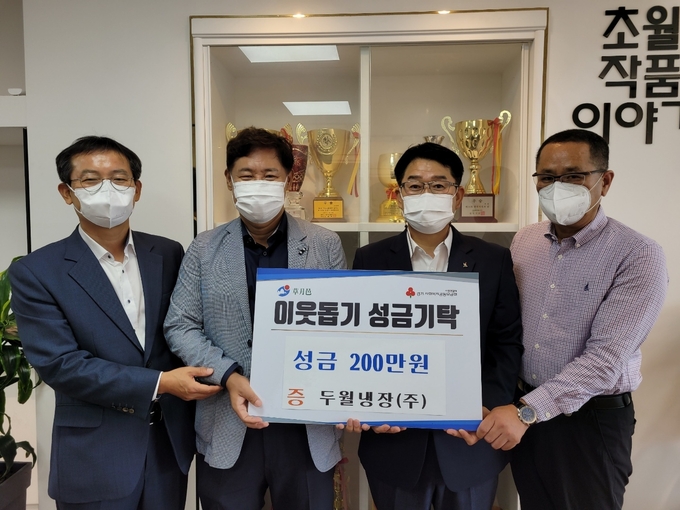 광주시 초월읍 ㈜두월냉장 백남조 대표가 구정서 초월읍장에게 성금 200만원 기탁하고 있다/광주시 제공