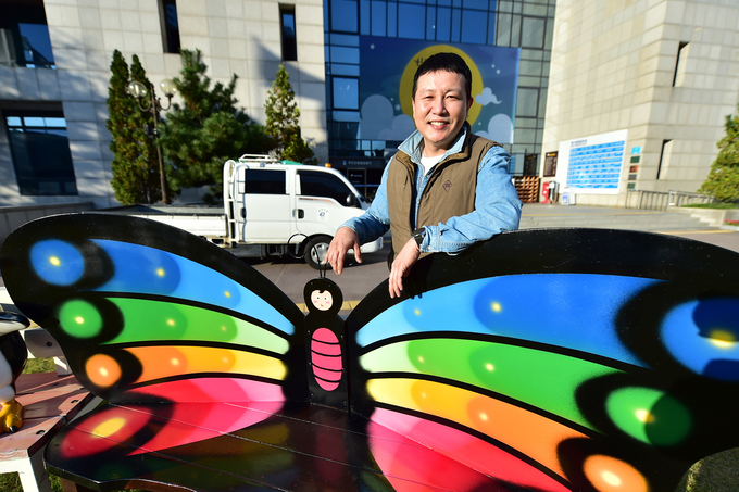 자신이 만든 나비의자와 함께 자세를 취한 김윤철 주무관. ( 사진 = 부평구 제공 )