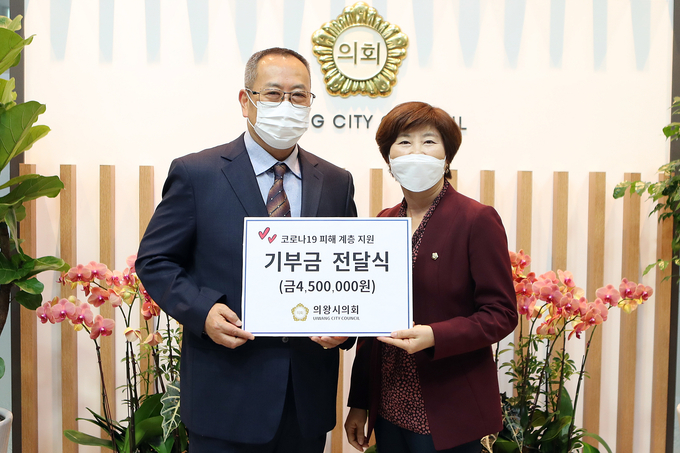 윤미경 의왕시의회 의장이 기부금 450만 원을 전달하며 이종득 지역사회보장협의체 위원장과 기념촬영을 하고 있다. (사진=의왕시의회 제공)