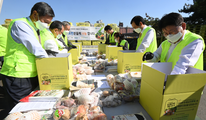 28일 수원시 권선구 농협 수원유통센터에서 열린 '한국새농민 경기도회 농산물꾸러미 나눔행사'에서 정용왕 농협 경기지역본부장, 김안석 한국새농민중앙회 회장, 홍응유 한국새농민 경기도회 회장, 윤신일 대한적십자사 경기도지사 회장 등 참석자들이 농산물 꾸러미를 포장하고 있다. (사진=조병석 기자)