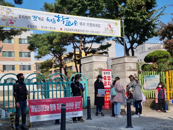 지난 29일 신갈초등학교 앞에서 아이들의 안전을 위한 캠페인을 진행 중인 용인시 배달 노동자와 학부모들의 모습. (사진=신경철 기자)