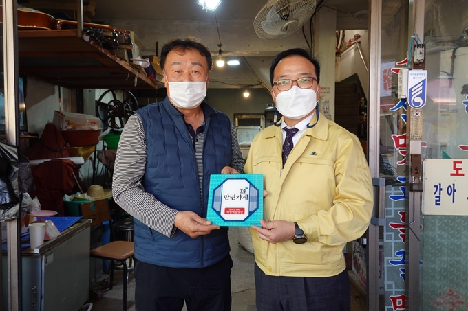 이영철 안양만안구청장이 30년 이상된 가게를 찿아 인증판(만년가게) 수여하고 있다. (사진=안양시 제공)