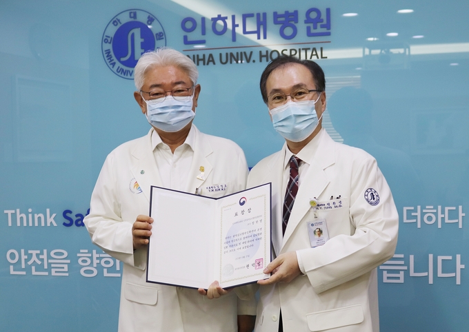 보건복지부 장관상을 받은 정한영 교수(오른쪽)가 김영모 인하대병원장과 기념촬영을 하고 있다. ( 사진 = 인하대병원 제공 )