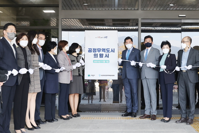 지난 1일 의왕시청 출입문 앞에서 ㈔한국공정무역마을위원회로부터 인증받은 '공정무역도시' 현판 제막식에서 참가자들이 기념촬영을 하고 있다. (사진=의왕시 제공)