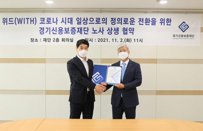 이민우 경기신용보증재단 이사장(오른쪽)이 2일 경기신보 회의실에서 경기신보 노조와 ‘위드(With) 코로나 시대, 일상으로의 정의로운 전환을 위한 경기신용보증재단 위드 코로나 노사 상생 협약’을 체결했다. (사진= 경기신보 제공)
