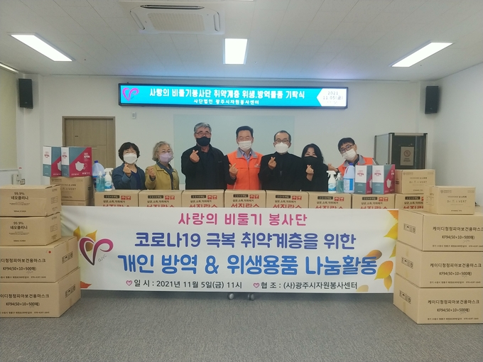 사랑의 비둘기봉사단 이상우 회장, 이석원 단장 등 회원들이 KF94 마스크, 손소독제, 살균소독수 등 코로나19 방역위생품 등을 취약계층 개인에게 써달라며 ㈔광주시자원봉사센터에 기증하고 있다. (사진=광주시자원봉사센터 제공)