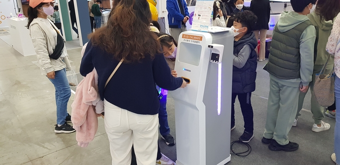 디지탈웨어의 휴대폰 소독 기능 제품을 체험하는 모습.