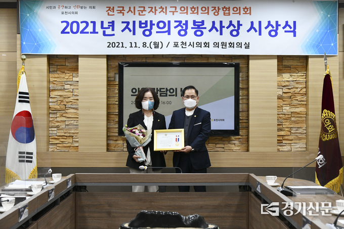 박혜옥 의원이 의장 직무대리 부의장 송상국 의원으로부터 의정봉사상을 전달받고 기념촬영하고 있다. (사진=포천시의회 제공)