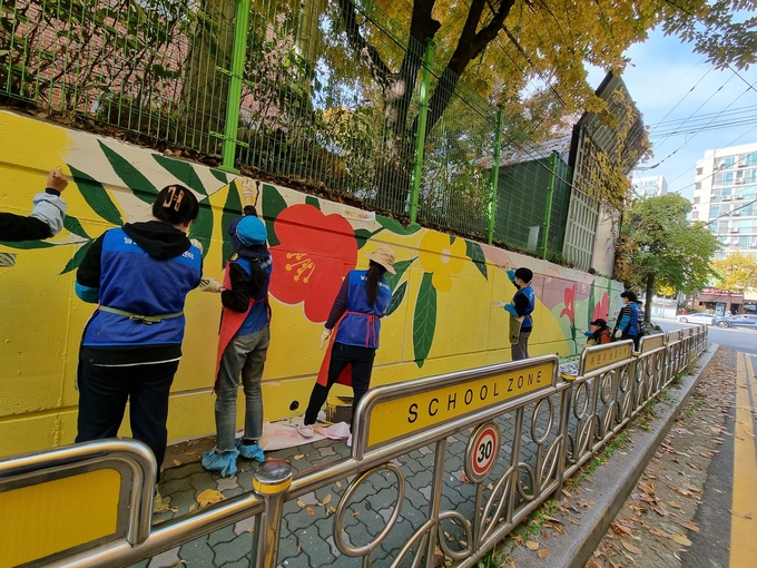 네오맨벽화사업단 봉사자들이 청선학교 담장에 벽화를 그리고 있다. ( 사진 = 남동구 제공 )