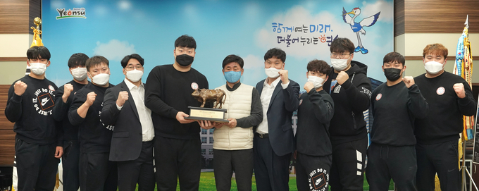 천하장에 오른 김찬영 선수(왼쪽 5번째)가 고남석 구청장에게 우승트로피를 전달하고 있다. ( 사진 = 연수구 제공 )