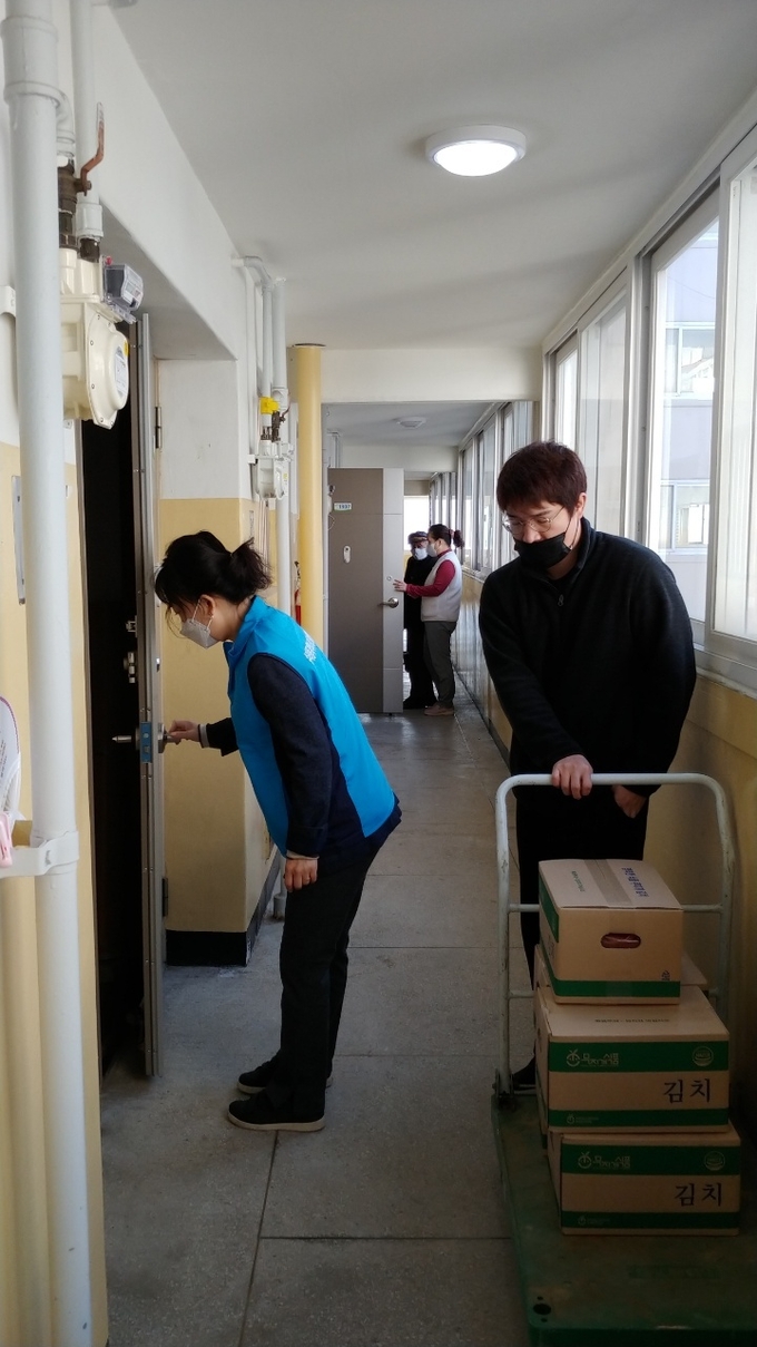 군포시 수리동 지역사회보장협의체 위원들이 거동이 불편한 노약자 가구에 김장김치를 전달하고 있다. (사진=군포시 수리동 제공)