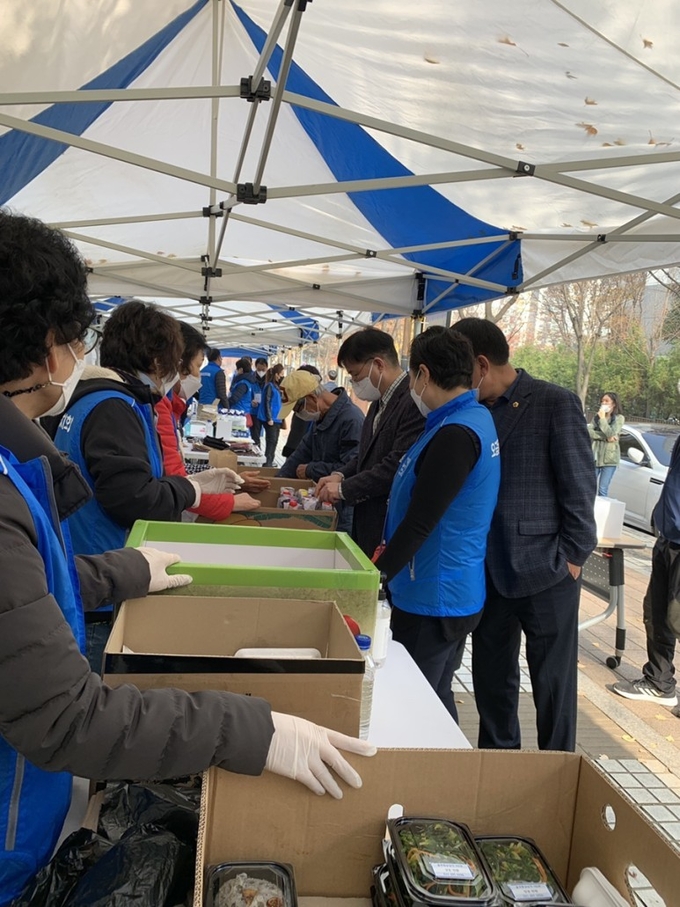군포시 오금동 주민자치회의 ‘사랑의 나눔 바자회’에서 한대희 시장(오른쪽에서 세 번째)이 바자회 판매물품을 살펴보고 있다
