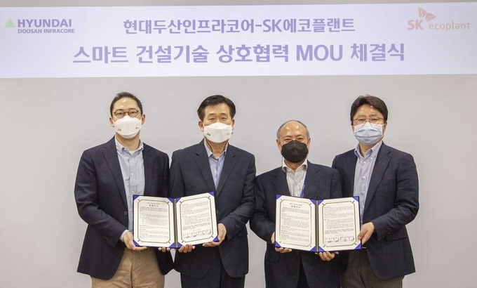 현대두산인프라코어와 SK에코플랜트 관계자들이 스마트 건설기술 상호협력 양해각서를 체결한 뒤 기념촬영을 하고 있다. 오른쪽부터 현대두산인프라코어 전략기획부문 이윤석 상무, 기술원 이동욱 부사장, SK에코플랜트 장효식. ( 사진 = 현대두산코어 제공 )
