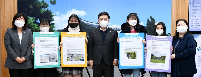 광주시 아동참여위원회는 신동헌 시장에게 아동의 평균키(120㎝)에 맞는 버스 손잡이·하차벨 설치 등의 정책 제안서를 전달하고 있다. (사진=광주시 제공)