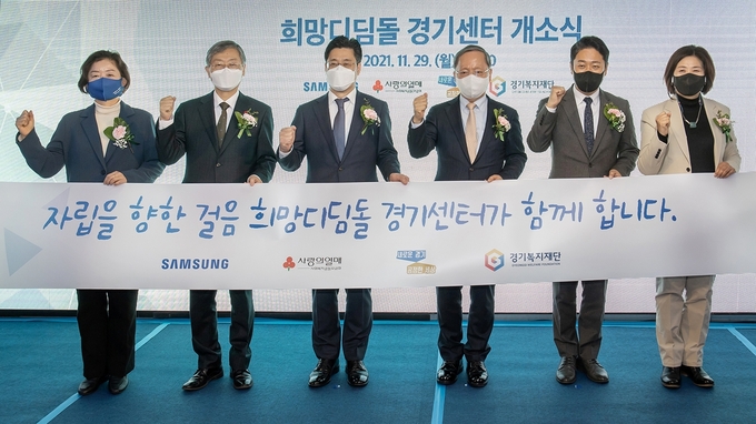 화성시에 있는 '삼성 희망디딤돌' 경기센터 개소식에 참석한 관계자들이 자립 준비 청소년들을 응원하고 있다. 왼쪽부터 문경희 경기도의회 부의장, 조흥식 사랑의열매 회장, 오병권 경기도지사 권한대행, 박학규 삼성전자 DS 부문 경영지원실장 사장, 진석범 경기복지재단 대표이사, 왕성옥 경기도의회 보건복지위원회 위원. (사진=삼성전자 제공)