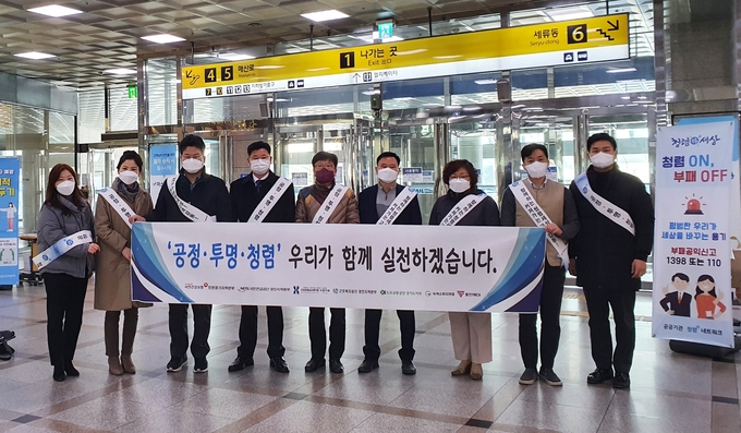 29일 수원역 역사 내에서 국민건강보험공단 인천경기지역본부와 경인 공공기관 청렴 협의체인 ‘청렴플러스 네트워크’ 및 소비자‧시민단체 회원들이 반부패‧청렴 실천 캠페인 관련 기념사진을 찍는 모습. (사진=국민건강보험공단 인천경기지역본부)