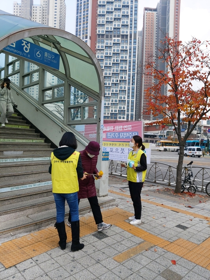 군포시 무한돌봄센터 직원들이 시민들에게 겨울철 위기가구 발굴을 위한 홍보물을 나눠주고 있다. (사진=군포시 제공)
