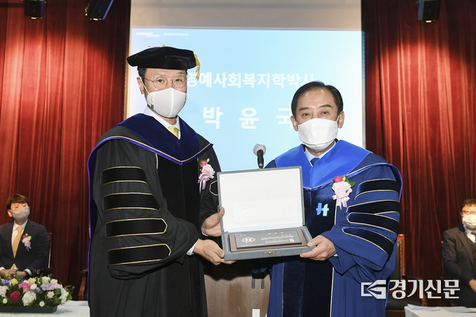 박윤국 포천시장이 강성종 신한대 총장으로부터 사회복지학 명예박사 학위증을 수여받고 있다. (사진=포천시 제공)