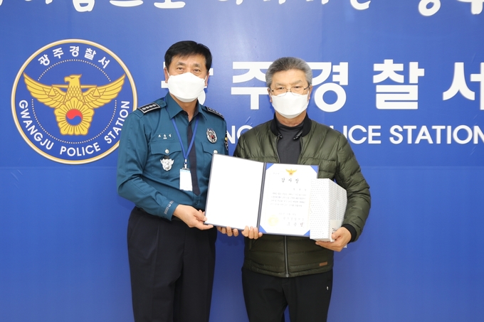 조용성 광주경찰서장이 보이스피싱 피해를 예방한 택시기사 A씨에게 감사장과 신고포상금을 수여하고 있다. (사진=광주경찰서 제공)