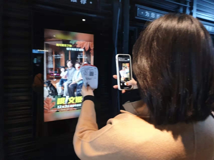 3일 오후 중국 베이징 한 극장에서 한 중국인 관람객이 영화 '오! 문희' 포스터 앞에서 인증샷을 찍고 있다. (사진=연합뉴스)