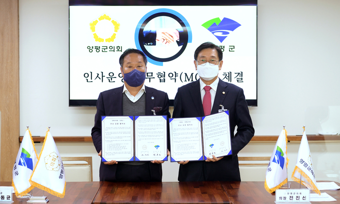 전진선 양평군의회 의장(사진 오른쪽)과 정동균 양평군수가 '지방자치법' 전부 개정에 의한 의회 인사권 독립에 따른 업무협약서에 서명하고 협약서를 들어보이고 있다. (사진=양평군의회 제공)