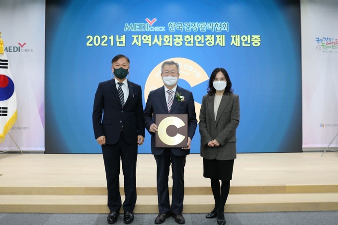 건협 채종일 회장(좌측 두 번째), 최상철 홍보기획실장(좌측 첫 번째), 김현경 홍보기획부장(우측 첫 번째)이 2021 지역사회공헌 인정기관 선정 기념사진을 찍고 있다. (사진=한국건강관리협회 제공)