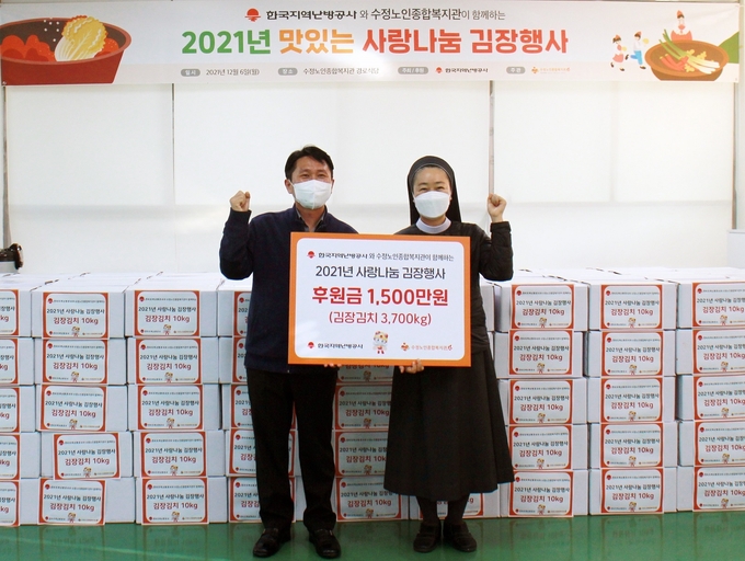 최세한 행복나눔단 총괄간사(사진 왼쪽)가 진현정 수정노인종합복지관장(하상바오로 수녀)로부터 김장김치를 전달받고 기념촬영을 하고 있다. (사진=한국지역난방공사 제공)