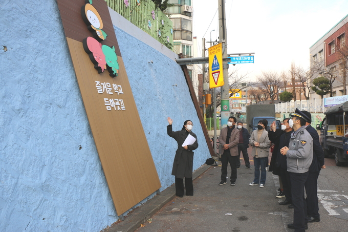 안심 통학로 조성 완공행사에 참석한 관계자들이 벽화에 대한 설명을 듣고 있다. ( 사진 = SK인천석유화학 제공 )