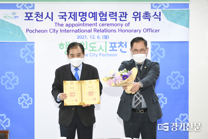 화상 참여 위원에게 박윤국 시장이 위촉장을 송상국 포천시의회 의장직무대리 부의장이 꽃다발을 건내고 있다. (사진=포천시 제공)