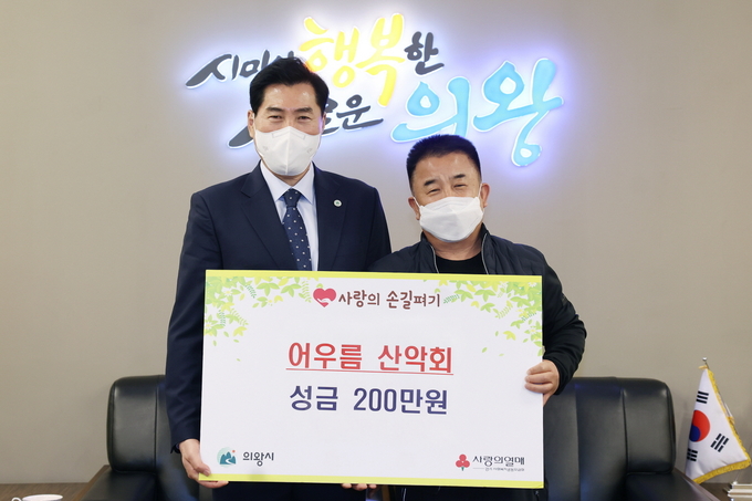 8일 김상돈 의왕시장(사진 왼쪽)이 신상균 어우름산악회장(오른쪽)으로부터 저소득층을 돕는데 써달라며 성금 200만 원을 전달받았다. (사진=의왕시 제공)
