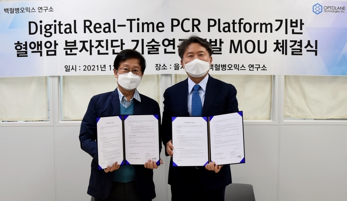백혈병오믹스연구소장 김동욱 소장(사진 왼쪽)과 옵토레인 이도영 대표이사가 협약식 후 기념촬영을 하고 있다. (사진=을지대학교 제공)