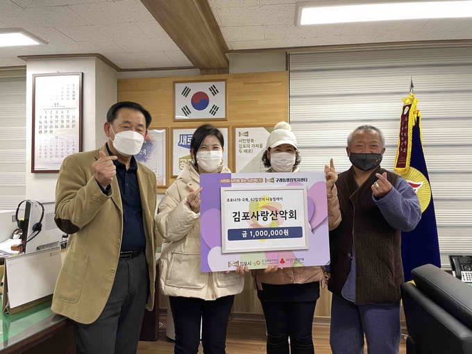 나눔릴레이에 동참한 김포사랑산악회와 시립호수 공원 어린이집, 시립호수 어린이집 원장 등이 구래동 사무소를 찾아 성금을 기탁하고 있다.(사진=구래동사무소제공) 