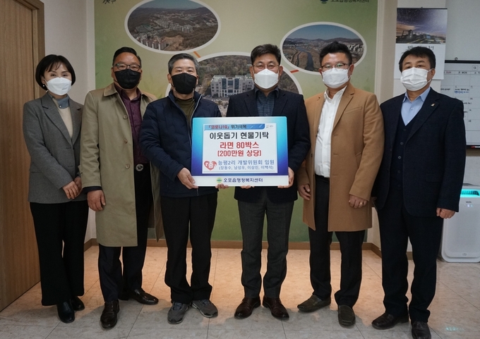 광주시 능평2리 개발위원회는 어려운 이웃들에게 전달해 달라며 라면 80박스(200만원 상당)를 기탁하고 있다/광주시 제공