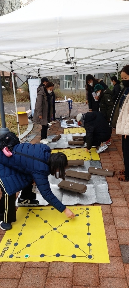 큰 별 마을 전통놀이에 참여한 한 주민이 윷놀이를 하며 즐거워 하고 있다. (사진=광주시 제공)
