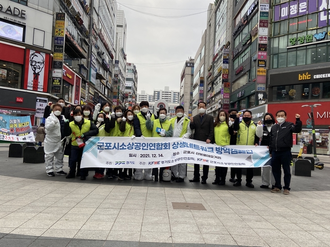 군포시 소상공인연합회와 소상공인들이 산본로데오거리에서 방역소독과 캠페인을 마치고 한 자리에 모였다. (사진=군포시 제공)