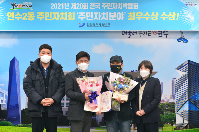 고남석 구청장이 최우수상을 받은 연수2동 주민자치회에 상장과 꽃다발을 전달하며 축하하고 있다. ( 사진 = 연수구 제공 )