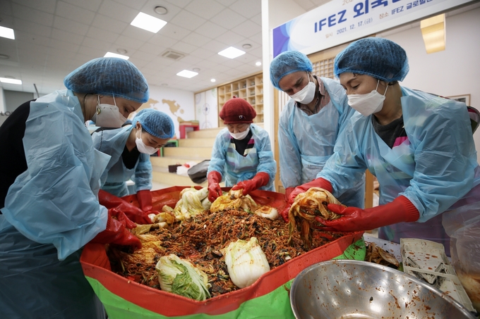 행사에 참가한 외국인들이 열심히 김장김치를 담그고 있다. ( 사진 = 인천경제청 제공 )