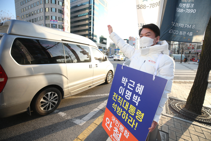 국민의당 안철수 대선 후보가 20일 오전 대구 중구 지하철 2호선 경대병원역 인근에서 이명박·박근혜 전 대통령의 석방을 촉구하는 피켓을 들고 출근길 시민에게 인사하고 있다. (사진=연합뉴스)
