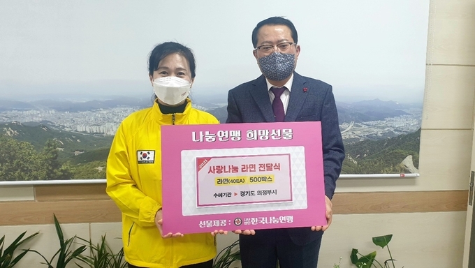 (사)한국 나눔연맹 강현애 부장(좌)이 윤교찬 의정부시 복지국장에게 라면 500상자를 전달하고 있다.(사진= 의정부시 제공)